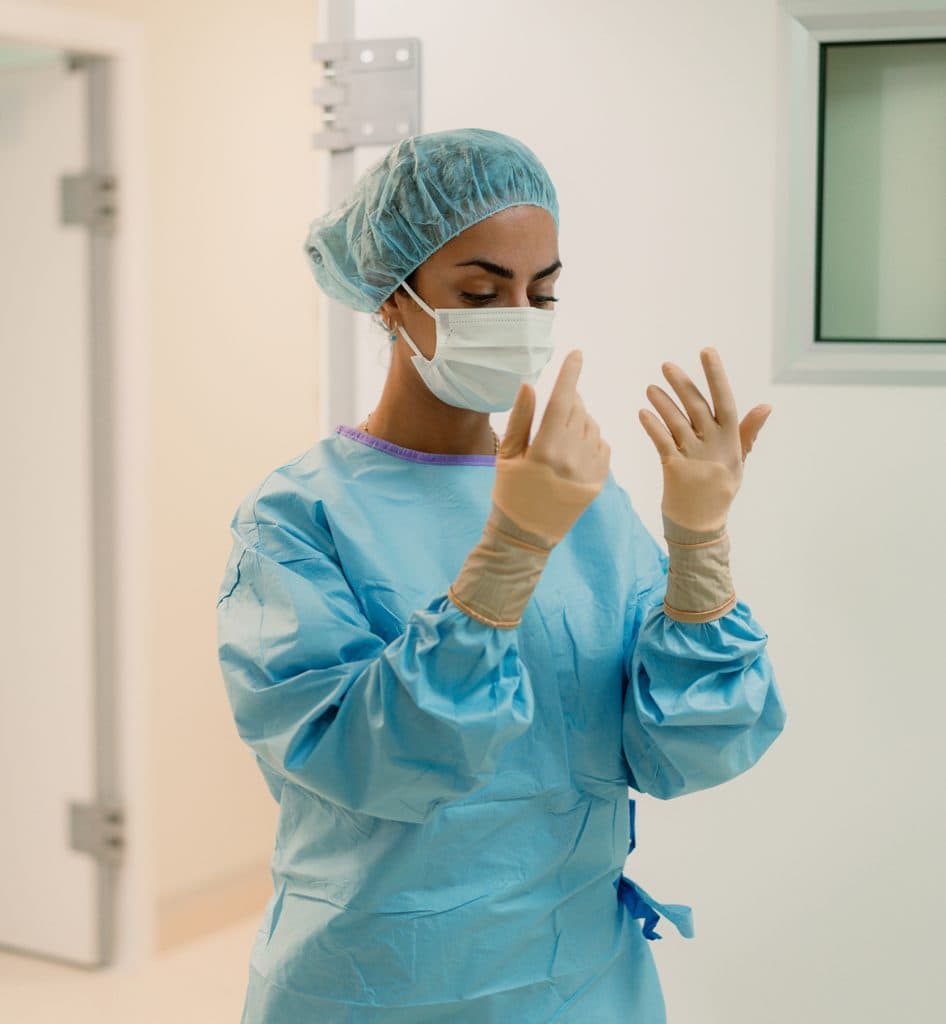 Högskoleutbildad veterinär i skyddskläder inför en operation eller undersökning på klinik.